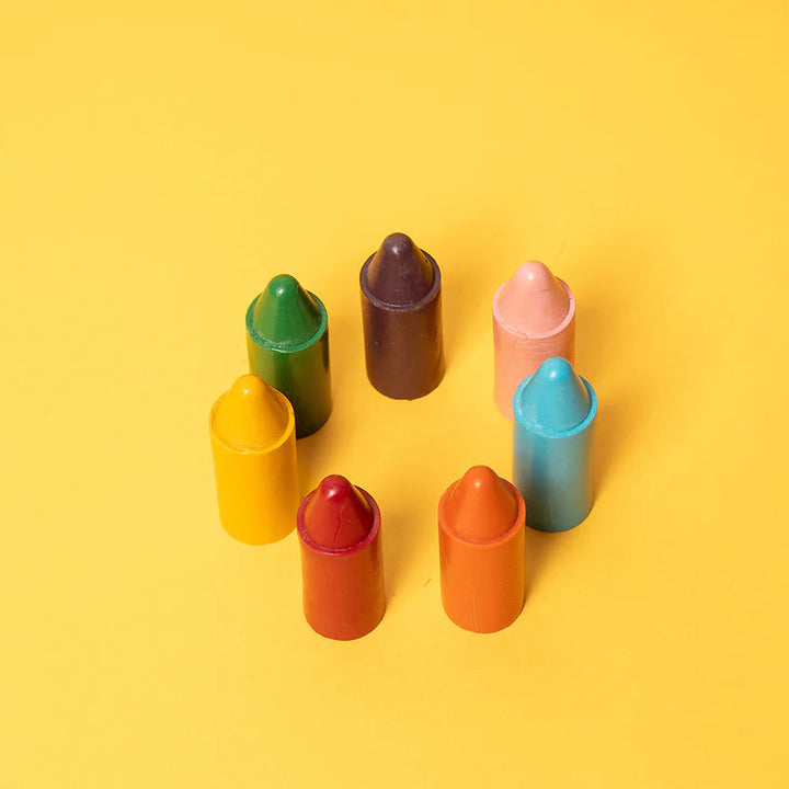 Assorted colorful lip balm tubes on a yellow background