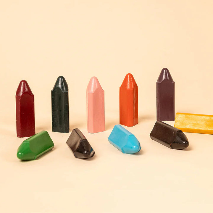 Assorted colorful crayon-shaped candies on a beige background