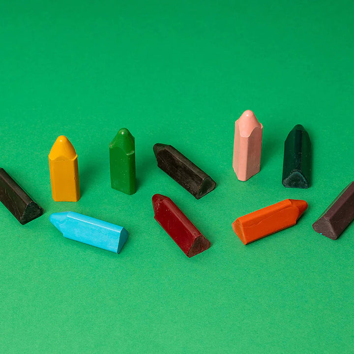 Assorted colorful crayon pieces on a green background
